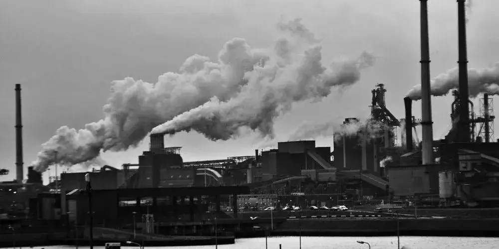 モノクロの工場から出る煙の写真